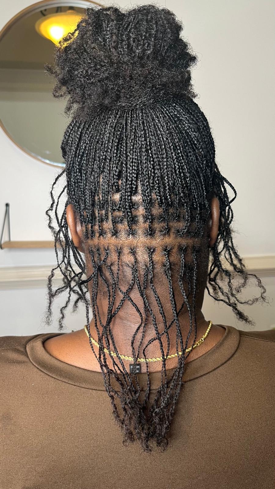 Micro braids with loose wavy ends and a top bun by Amajoris