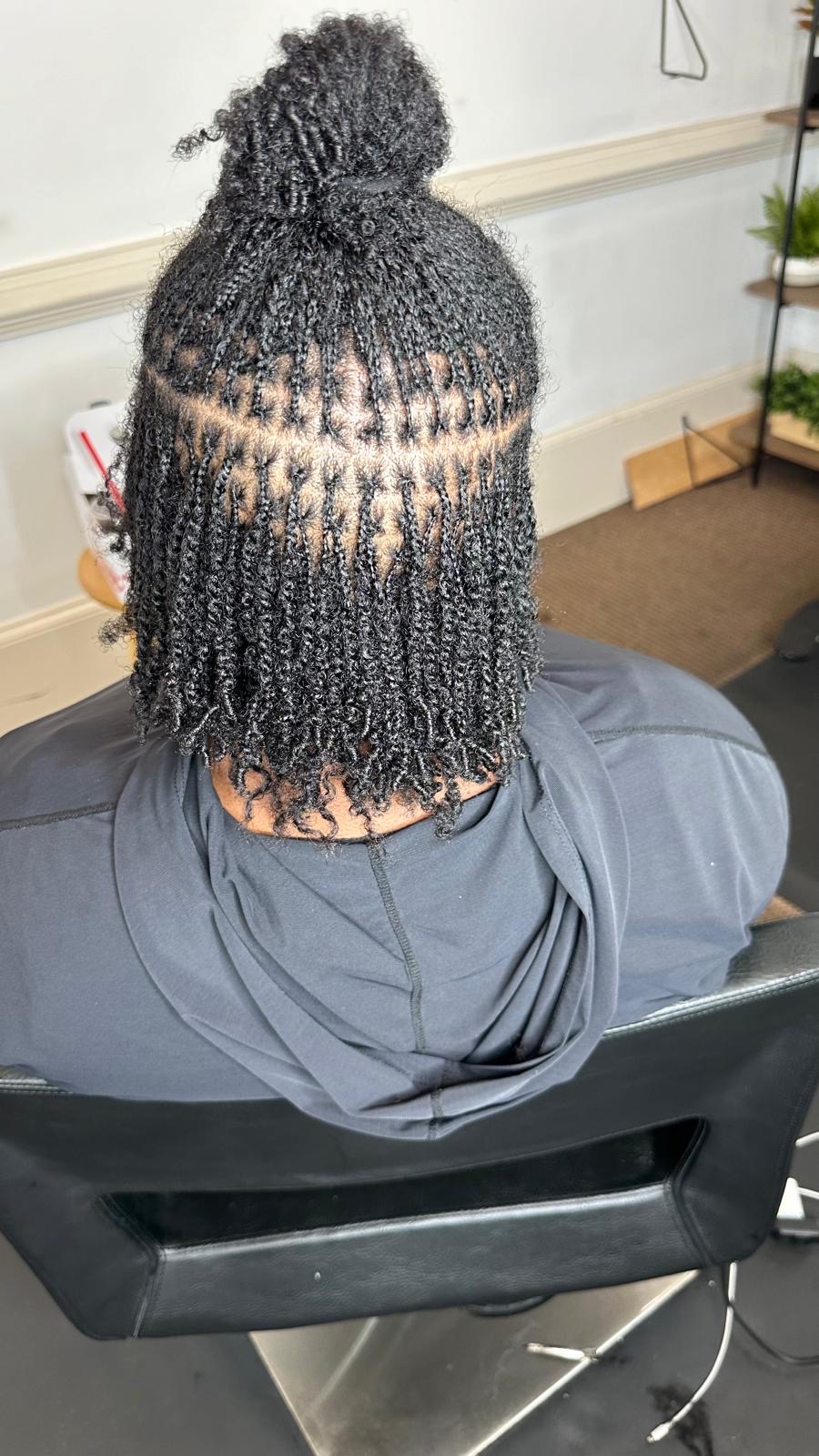 Micro braids with curly ends gathered into a bun by Amajoris