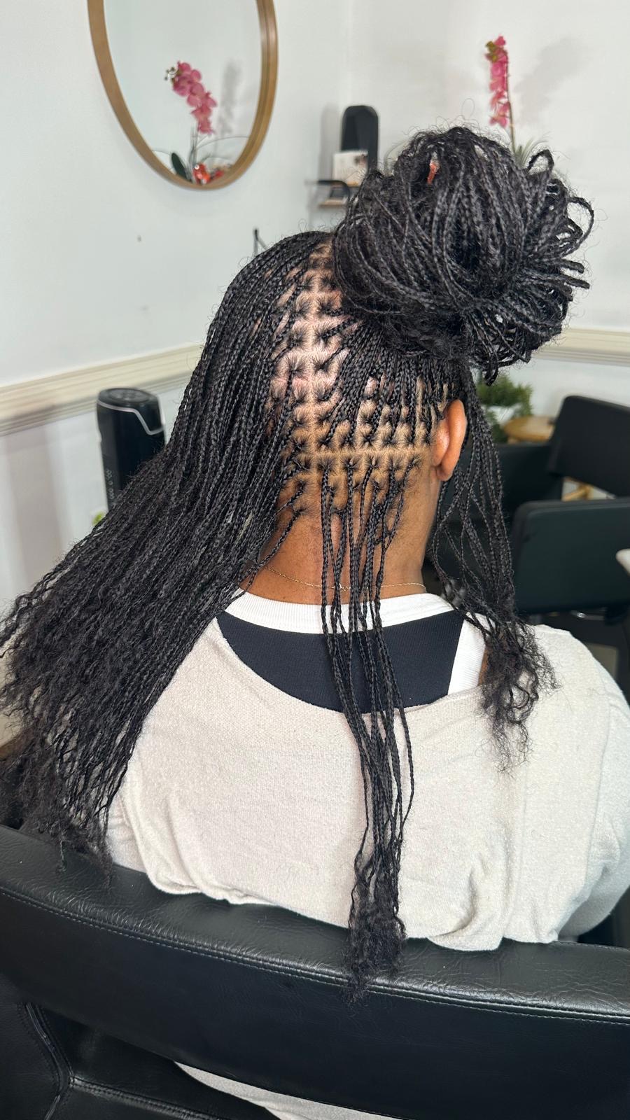 Long micro braids in a half-up bun showing clean parting by Amajoris