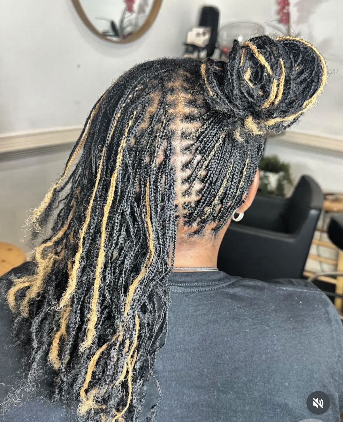 Micro braids swept into a gold-accented bun by Amajoris
